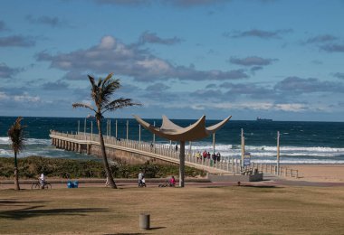 People walking on a pier leading into the sea, durban
