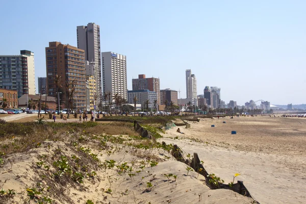 Dunas de areia e pessoas contra o horizonte da cidade — Fotografia de Stock