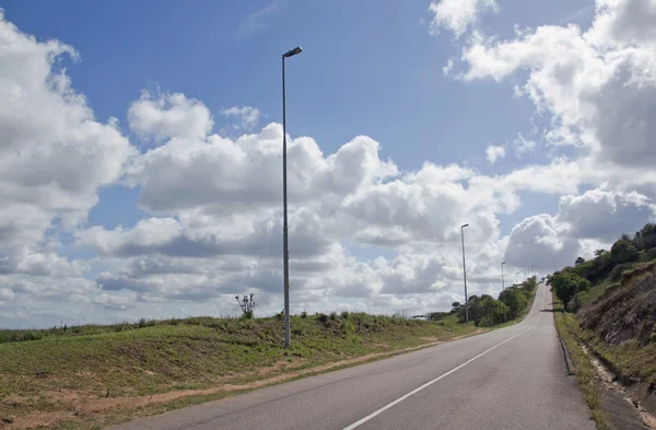 Dlouhé rovné prázdné silnici asfaltu s pouliční lampy — Stock fotografie