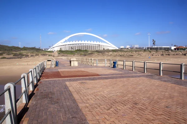 Beskåda av Moses Mabhida Stadium från piren på Durban Beach — Stockfoto