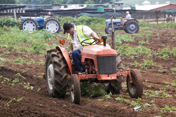 Återställas Vintage gården traktor plöja fältet för plantering — Stockfoto