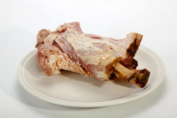 Zbytky a kosti vyčnívající z pozůstatků pečená uzená šunka — Stock fotografie