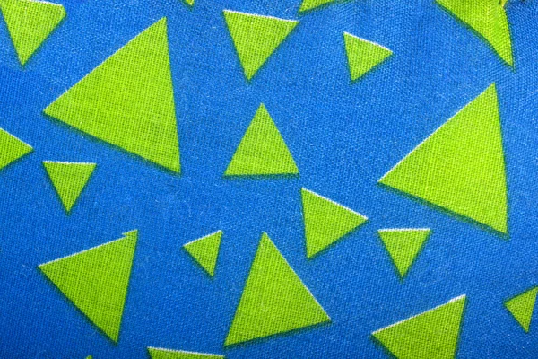 Triangles de matériau vert sur tissu bleu vif — Photo