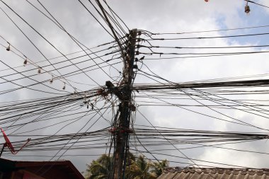 Ahşap kutbuna bağlı elektrik kabloları dizeleri