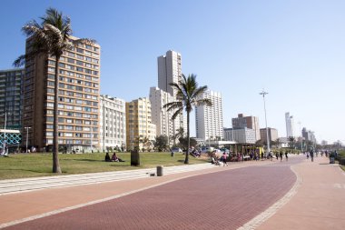 People on Beach Front Promenade Against City Skyline 