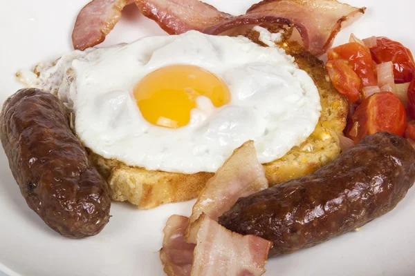 Närbild frukost med ägg, rostat bröd, Bacon, korv och tomat — Stockfoto