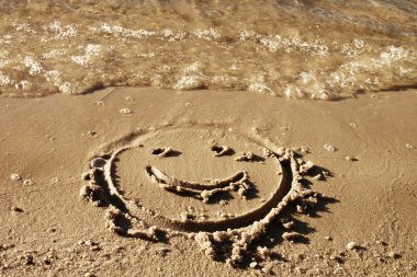 Deniz kenarında ıslak kum çizilmiş eğlenceli gülümsemek yüz