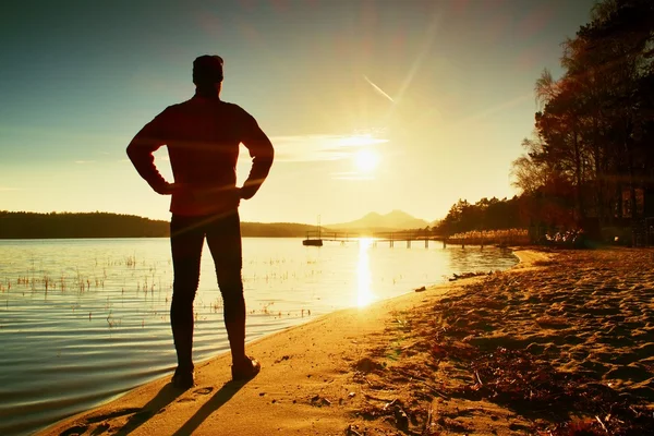 Sylwetka wysoki sportowca na spadek widząc nad zatoką słońce — Zdjęcie stockowe