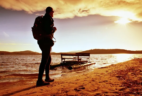 Wandelen langs de zee. Man met rugzak lopen op strand van roestig waterfiets. Herfst op zee. — Stockfoto