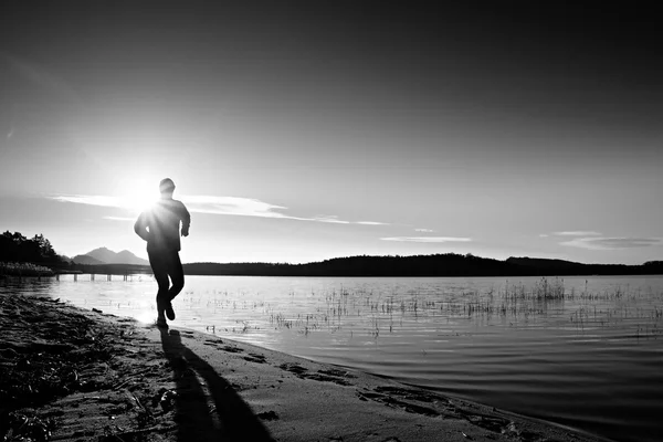 Sportsman courir à incroyable coucher de soleil d'été le long de la côte dans le sport et le mode de vie sain — Photo