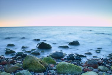 Denizde romantik sabah. Büyük kayalar pürüzsüz dalgalı denizden çıkmış. Uzun pozlama 