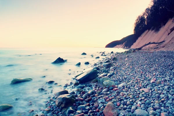 Blue sea and sky, waves break off stony shore. Moment before sunrise — Stock Photo, Image