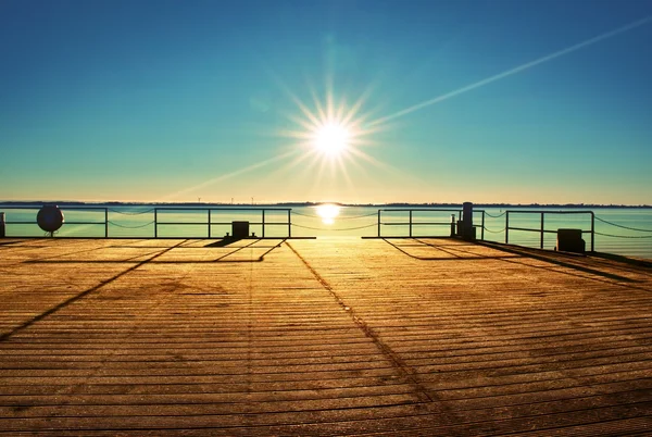 Molo di legno vuoto a bella mattina colorata. Pontile turistico nella baia di mare. — Foto Stock