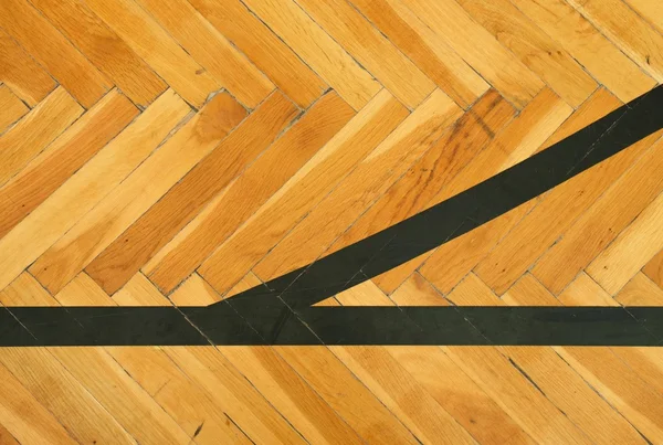 Чорні лінії в залі. Зношена дерев'яна підлога спортивного залу з барвистими лініями розмітки — стокове фото