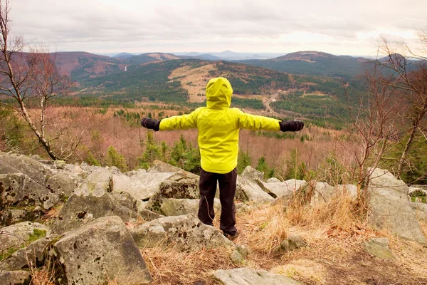 Menino de casaco quente amarelo ficar em uma rocha em um dia de primavera vento frio. Estilo de vida ativo, atividades ao ar livre, caminhada — Fotografia de Stock