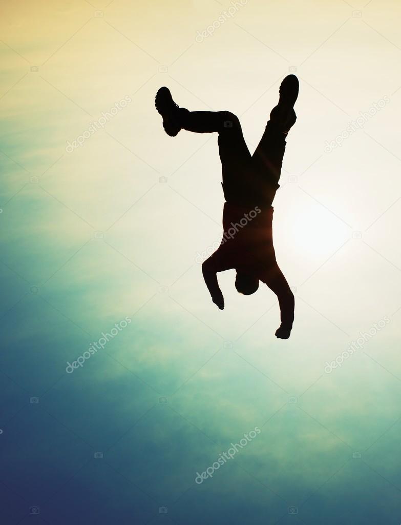 Flying man. Young man falling down on sky background.