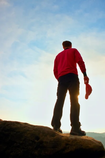 Vandrare i röd tröja med röd mössa på toppen av rock vakar över dalen till Sun. vackra ögonblick — Stockfoto
