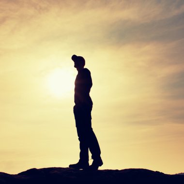 Siluet insan doğa daybreak arka plan üzerinde kayalık kaide üzerinde duran.