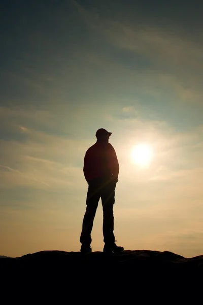 Silhouette umana in piedi su un piedistallo roccioso sulla natura daybreak sfondo . — Foto Stock