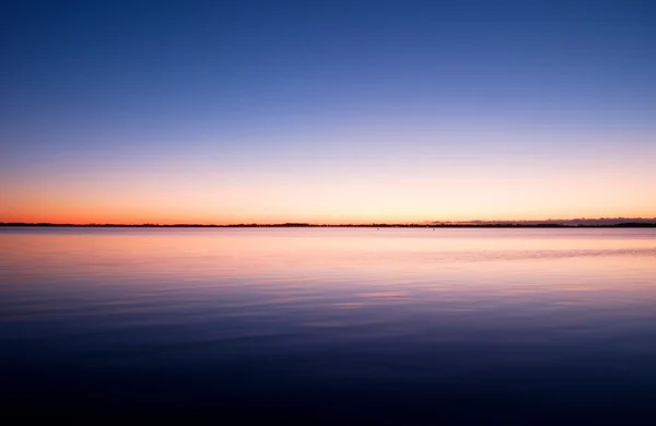 Перший світло дня створює драматичні кольори на небі над океаном. — стокове фото