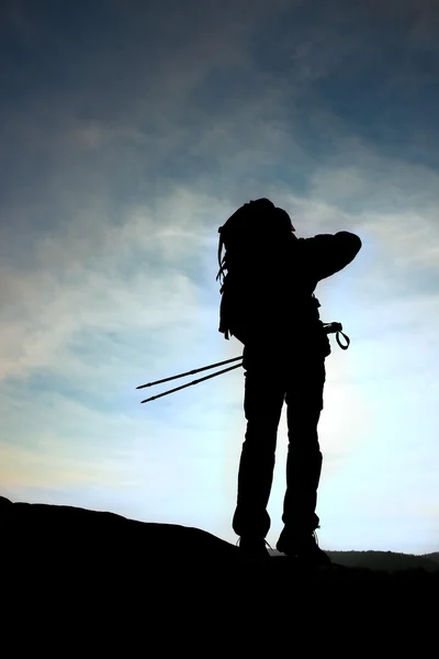 Man vandrare med vandringsstavar stå på mountain peak rock. Små pine bonsaiträd växer i rock, våren solig dag — Stockfoto