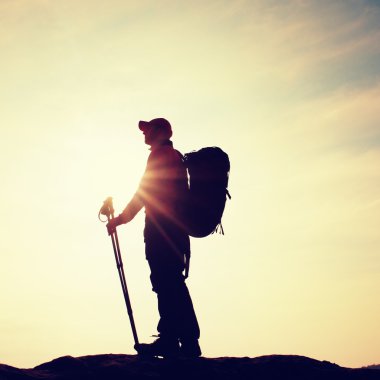 Windcheater turist ellerinde sportif trecking direkleri ile stand üzerinde kayalık bakış.