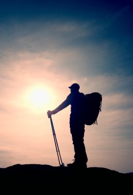 Windcheater turist ellerinde sportif trecking direkleri ile stand üzerinde kayalık bakış.
