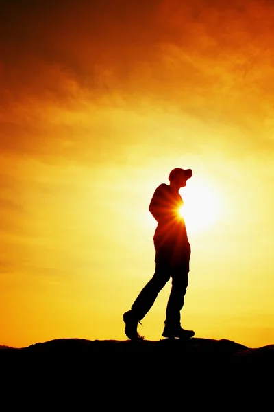 Caminante en sudadera roja con gorra roja en pico rocoso. Hombre vigilando valle a sol. Hermoso momento — Foto de Stock