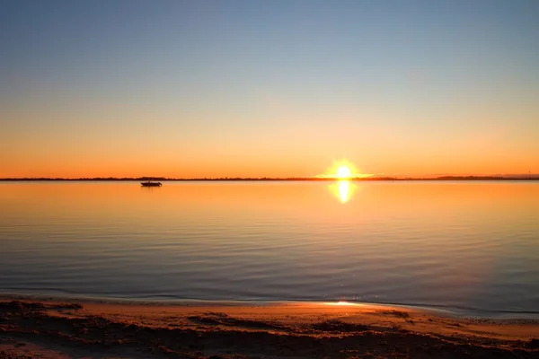 Nivel liso del lago en el cálido atardecer colorido, playa de arena —  Fotos de Stock