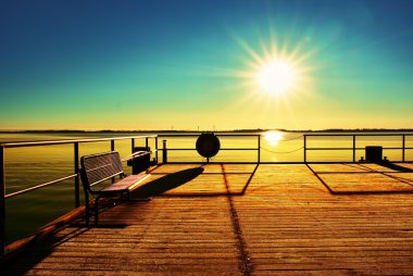 Güzel, renkli bir sabahta boş ahşap iskele. Deniz koyundaki turist iskelesi..