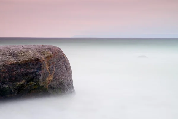 Atmosfera romântica em manhã tranquila no mar. Pedras grandes que se destacam do mar ondulado liso. Horizonte rosa — Fotografia de Stock