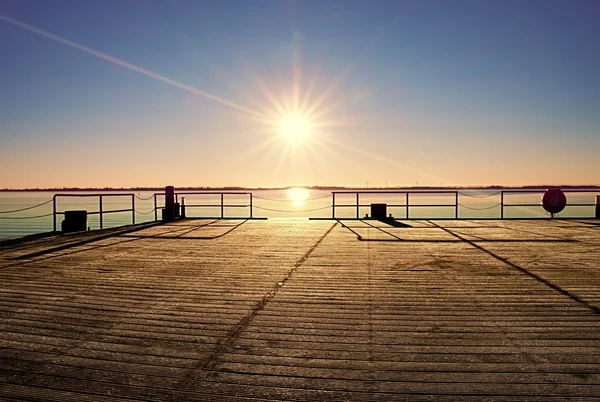 Molo di legno vuoto a bella mattina colorata. Pontile turistico nella baia di mare. — Foto Stock