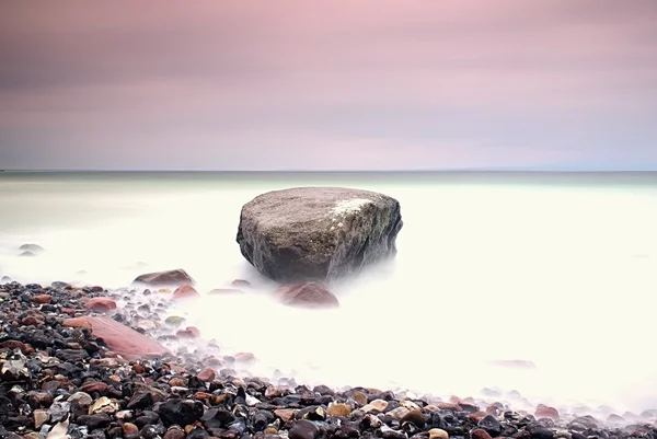 Romantische sfeer in rustige ochtend op zee. Grote keien van soepele golvende zee uitsteekt. Roze horizon — Stockfoto