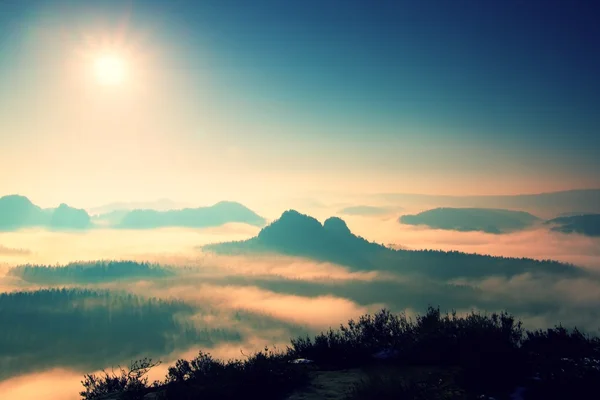 Fantástico amanecer de ensueño en la cima de la montaña rocosa con vistas al valle brumoso — Foto de Stock