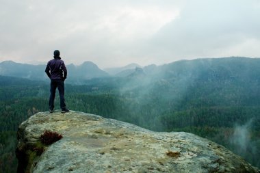 Uzun yürüyüşe çıkan kimse kumtaşı kaya kaya empires park ve puslu ve sisli bir bahar vadi izlerken keskin cliff üzerinde