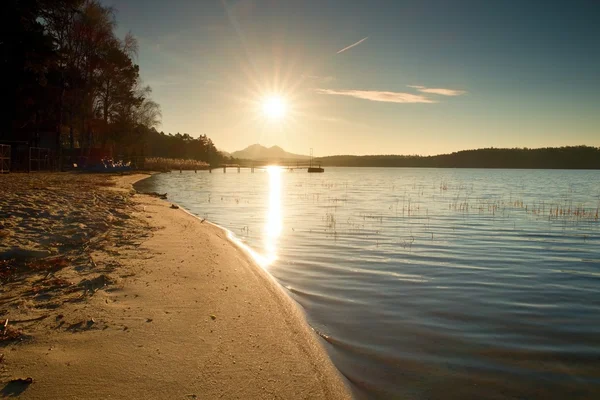 Kıyı, terk edilmiş iskele, renkli sonbahar gündoğumu. Ufuk kalesine ile ada. — Stok fotoğraf