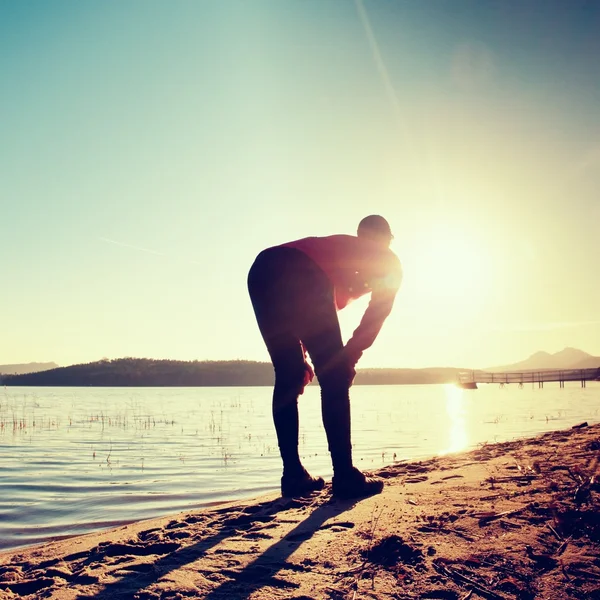 Corredor en ropa de fitness corriendo a lo largo de la costa de la playa con el cielo azul y el amanecer —  Fotos de Stock