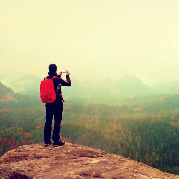 Touristin mit Rucksack macht Fotos mit Smartphone von Regenstauf. Melancholische Atmosphäre — Stockfoto