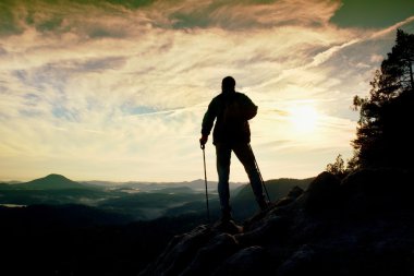 Polonyalılar el ile yalnız hiker silüeti. Turizm spor sırt çantası ile kayalık Görünüm noktası puslu Vadisi üzerinde durmak. Rocky Dağları'nda güneşli Bahar şafak.
