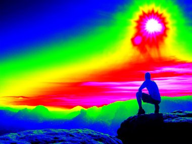 Adam kayalık tepe üzerinde. Fantastik Kızılötesi tarama. Ağır Sis içinde ultra violet ölçü renklerde derin vadi