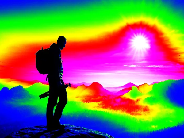 Homem no pico rochoso. Escaneamento infravermelho fantástico. Névoa pesada em vale profundo em cores de medição ultravioleta — Fotografia de Stock
