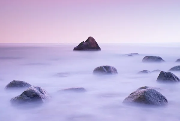 Закат на скалистом побережье моря. Низкая скорость затвора для плавного уровня воды и эффекта мечты — стоковое фото