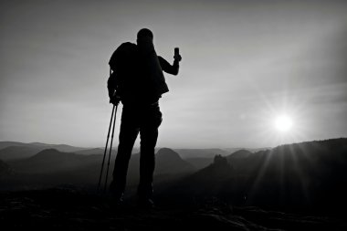 Uzun yürüyüşe çıkan kimse büyük sırt çantası ile akıllı telefon ile fotoğraf üzerinde kayalık tepe alır. Rüya gibi adamlara Vadisi aşağıdaki