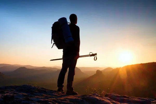 Silhueta afiada de um homem alto no topo da montanha com sol na moldura. Guia turístico nas montanhas — Fotografia de Stock