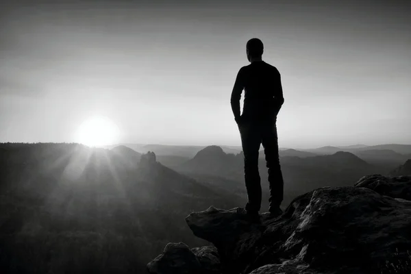 Тонкий турист на скале в парке Рок-Империи наблюдает за туманной и туманной утренней долиной до Солнца — стоковое фото