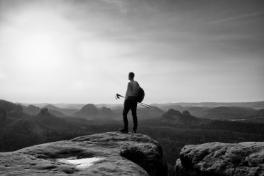 Uzun boylu kızıl saçlarını hiker gri t-shirt ve cliff üzerinde karanlık trekking pantolon. Adam turist Polonyalılar el ve vadi yukarıda sportif sırt çantası ile.