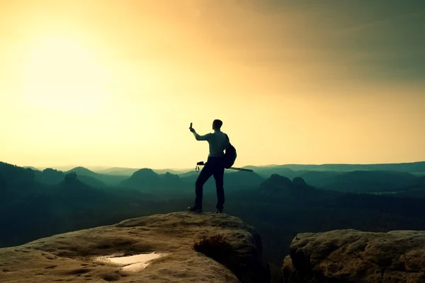 Fuerte excursionista tomando fotos con teléfono inteligente en el pico de la montaña. Maravilloso amanecer . — Foto de Stock