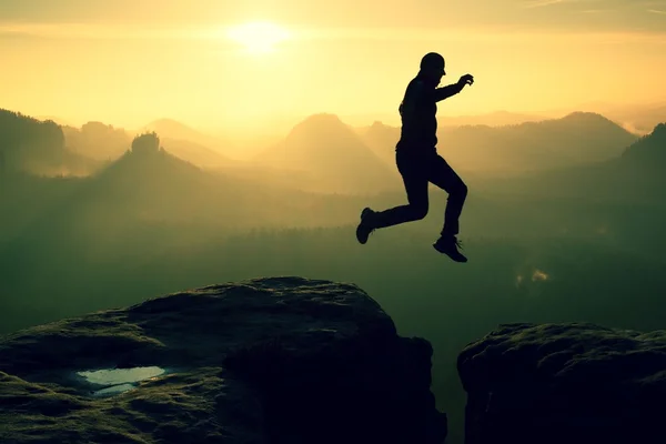 Crazy hiker jump between cliffs. Amazing mountains, heavy mist — Stock Photo, Image