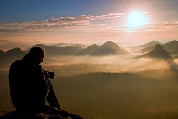 Silueta de fotógrafo profesional sobre un mar de nubes, montañas brumosas —  Fotos de Stock