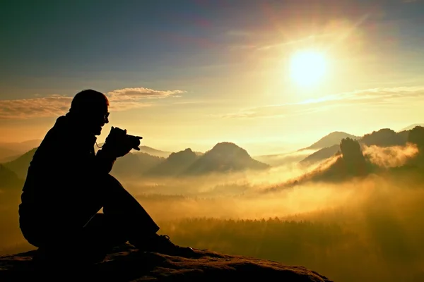 La photographie prend des photos du lever du jour au-dessus d'une vallée brumeuse. Vue paysage de collines de montagne d'automne brumeux et silhouette homme heureux — Photo